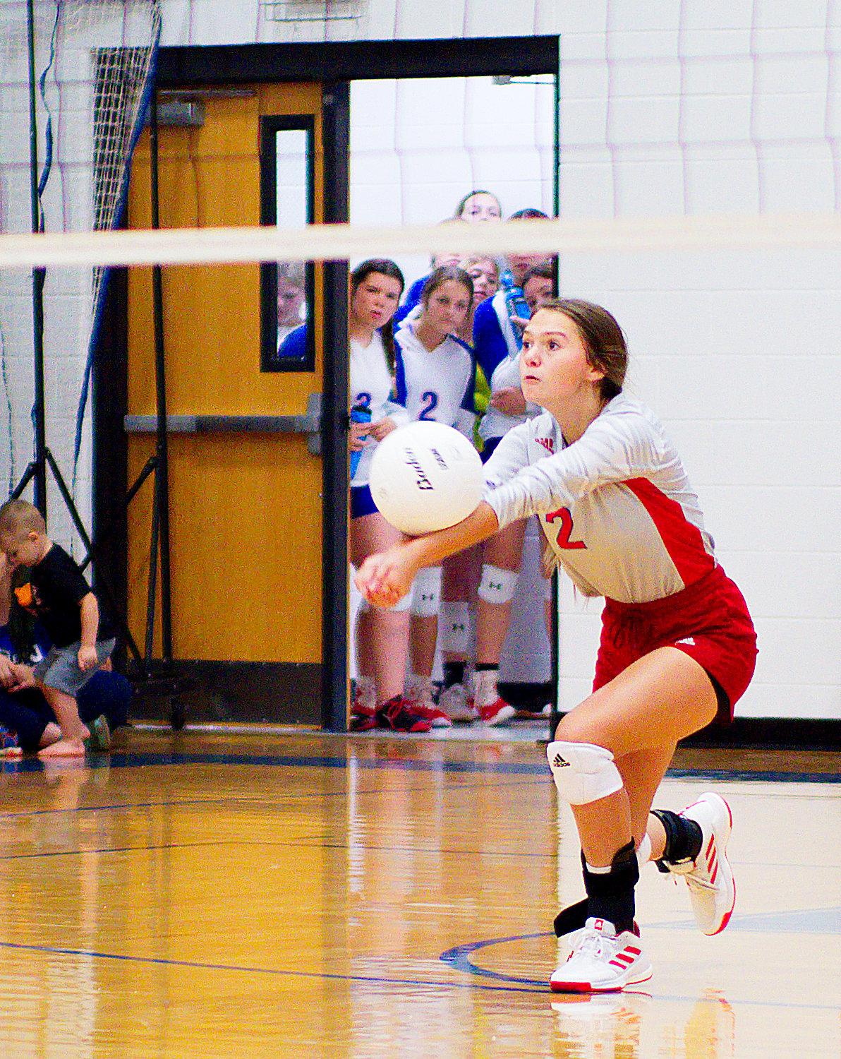 Kalli Trimble bumps the ball in the third set as the JV teams looks on. [see more from the Lady Panther win]